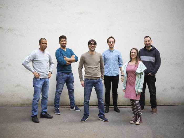 Das IGIT Team steht vor einer grauen Wand.